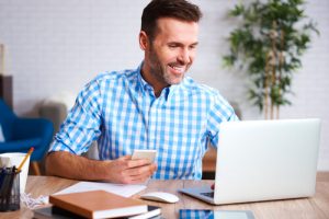 Employee calculating his benefits while looking at computer