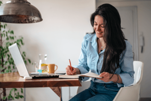 a female employee at a desk reviewing the employee handbook and highlighting sections