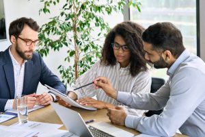 A team of managers reviewing payroll reports.