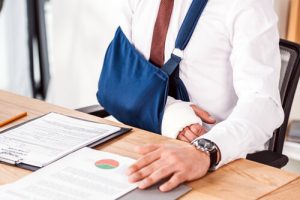 an employee with his arm in a sling after HR made a mistake of not having workers compensation
